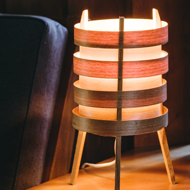 Wooden lamp with a warm glow on a wooden surface.