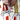 Close-up of a hand tufting on a colorful patterned rug with red, white, and yellow colors.