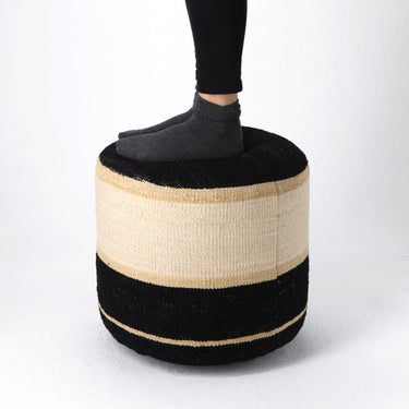 Person using a striped ottoman on a white background