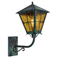 Vintage-style outdoor wall light with green patina and amber glass on a white background