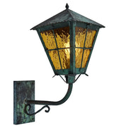 Vintage-style outdoor wall light with green patina and amber glass on a white background