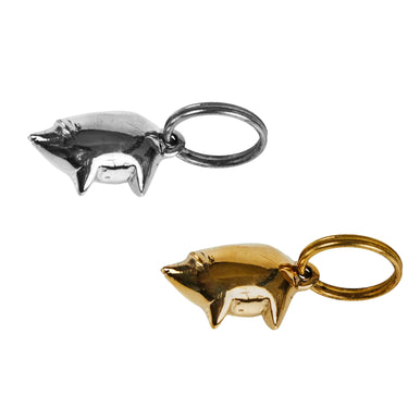Two pig-shaped keychains, one brass and one silver, on a white background.