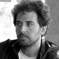 Black and white portrait of designer Marcos Catalan with a beard and tousled hair.