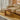 Beige sofa with a colorful striped kilim bench or stool in a modern living room.