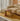 Beige sofa with a colorful striped kilim bench or stool in a modern living room.