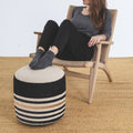 Person sitting on a chair with a striped ottoman in front