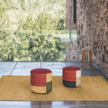 Two colorful kilim stools on a mat with a natural outdoor setting