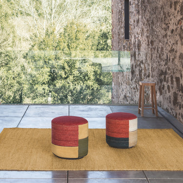 Two colorful kilim stools on a mat with a natural outdoor setting