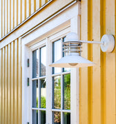 White danish outdoor wall light fixture on a yellow building exterior.