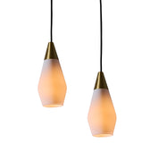 Two glass pendant lights similar to tynell or mauri almari with brass accents on a white background