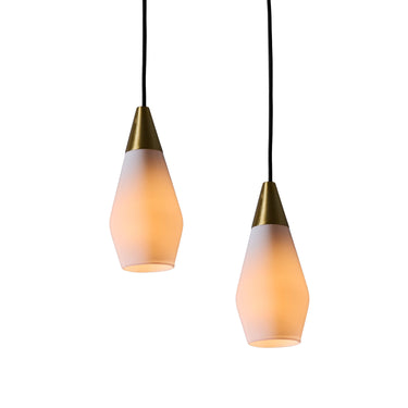 Two glass pendant lights similar to tynell or mauri almari with brass accents on a white background