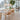 Modern dining room with wooden table and chairs, large windows, and a plant.