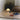 Small portable white lamp on a tatami mat with books and a pillow in a room.