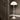 White 70s floor lamp against a dark wall with wooden floor and door.