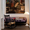 Living room with a painting on the wall, a rocking chair, and a lamp.