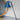 Blue desk lamp on a gray surface with a neutral background