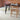 Dining table with chairs in a room with brick walls and leaf shaped rugs