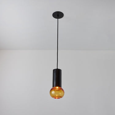 Pendant light with amber glass shade on a gray background