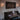Wooden piano in a room with a wall painting and window