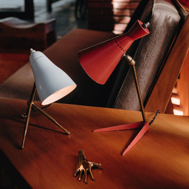 a pair of white and red vintage table lamps from the 1950s on a wood table