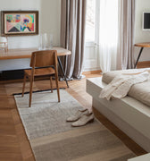 Modern living room with a sofa, rug, and decor elements.
