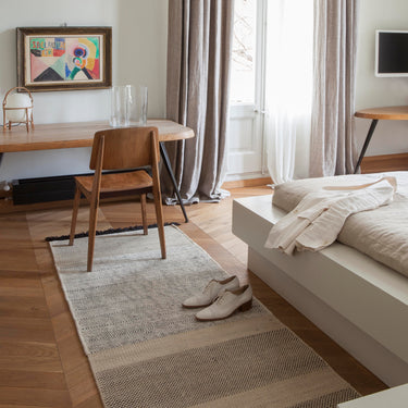 Modern living room with a sofa, rug, and decor elements.