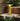 Yellow outdoor lamp on a stone ledge with plants around