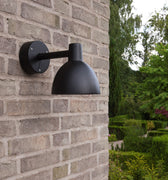 black modern outdoor wall light on brick wall toldbod louis poulsen model