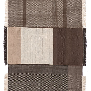 Textured dhurrie rug with a patchwork design featuring shades of brown and black on a white background.