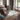 Living room with wooden floor, green rug, and jean prouvé chairs and royere sofa near large windows.