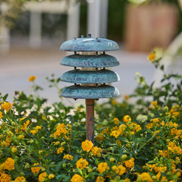 Decorative metal lantern among yellow flowers with a blurred garden background