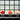 Three dome-shaped table lamps with metallic spring bases are lined up on a dark surface in front of a glass block window. The lamps have red, orange, and pale blush pink domes.