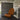Brown textured chair in a modern concrete room with a lamp.