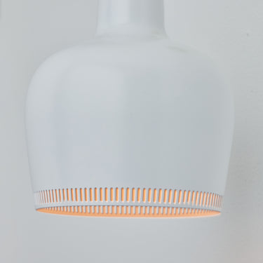 White pendant light with a circular cutout design on a gray background