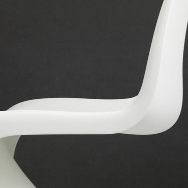 White curved chair on a black background