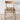 Wooden chair with a fringed blanket on a textured wool rug and light background